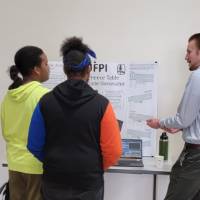 3 k-12 students looking at a senior project